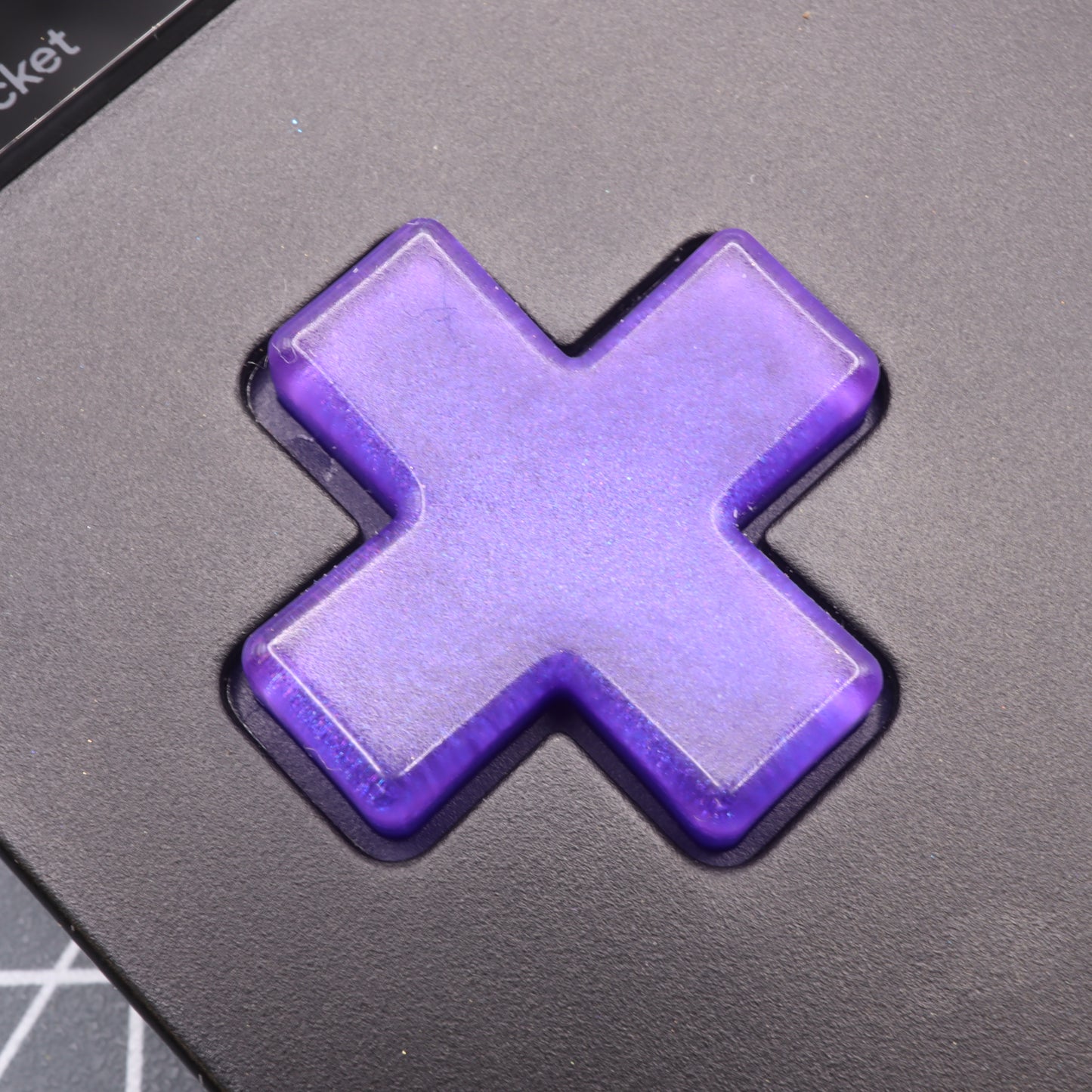 Close-up of a purple Grape Candy button on a black keyboard, crafted with precision for the Analogue Pocket using custom-cast molds.
