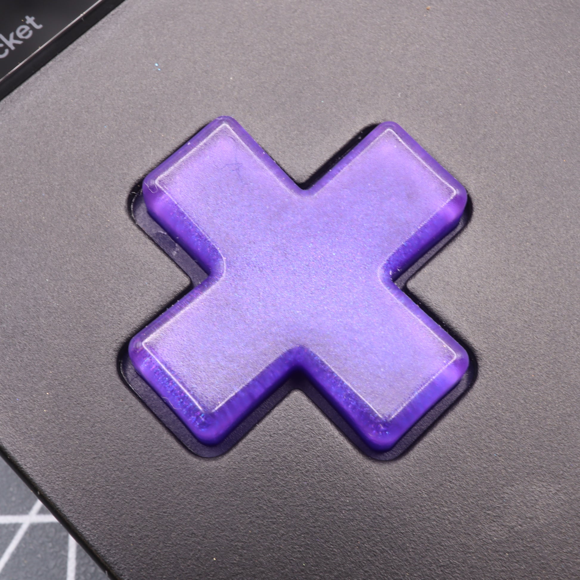 Close-up of a purple Grape Candy button on a black keyboard, crafted with precision for the Analogue Pocket using custom-cast molds.