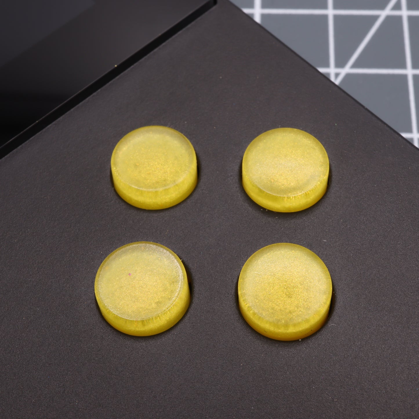 Four custom-cast Lemon Candy rubber pads are arranged in a square on a sleek black surface, echoing the tactile buttons of an Analogue Pocket.