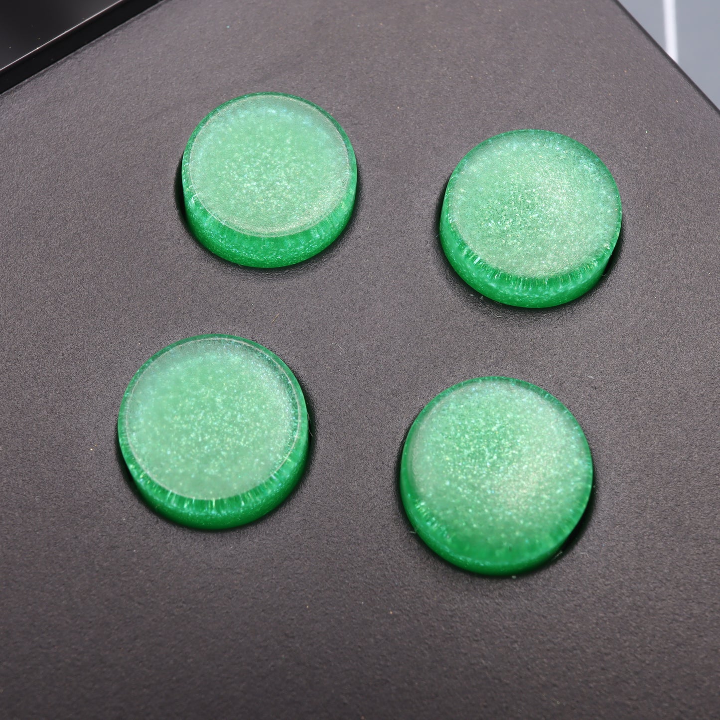 Four Lime Candy round buttons, reminiscent of Analogue Pocket buttons, rest elegantly on a dark surface.