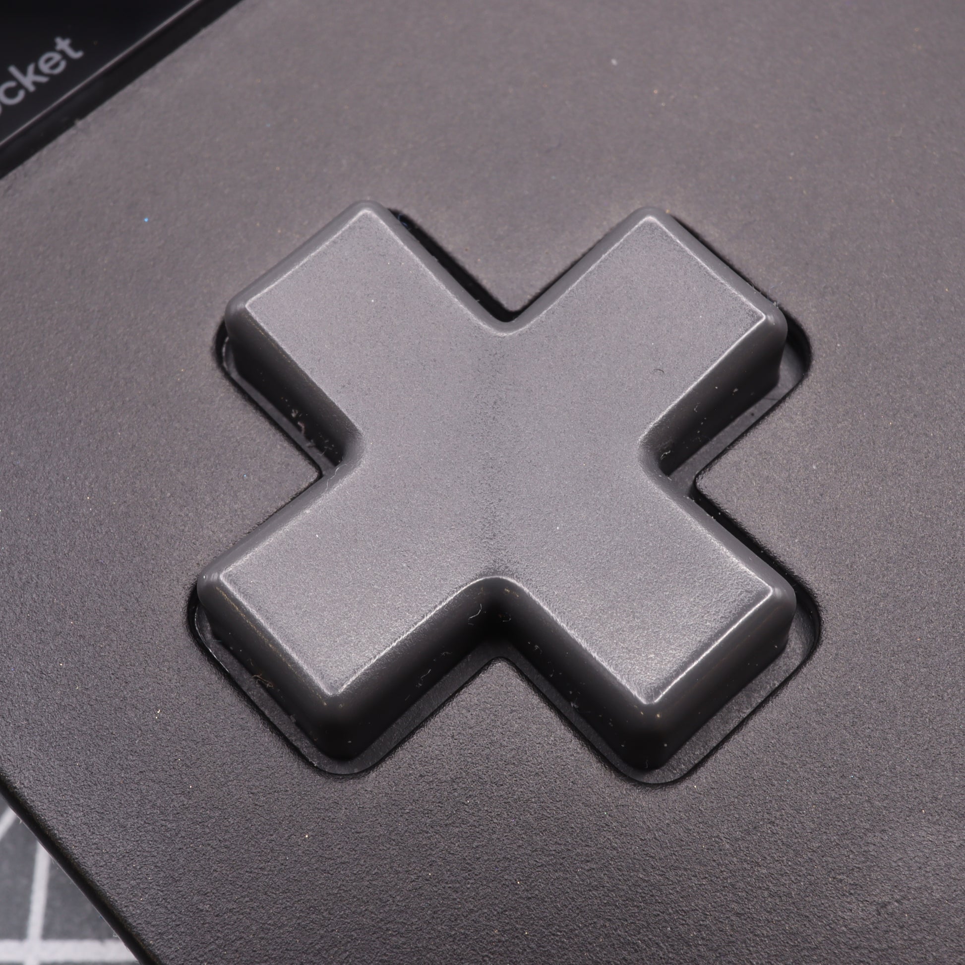 Close-up of the Analogue Pocket - Custom Button in a black cross shape, designed like a Game Boy DMG button with precision-crafted, handmade mold techniques.