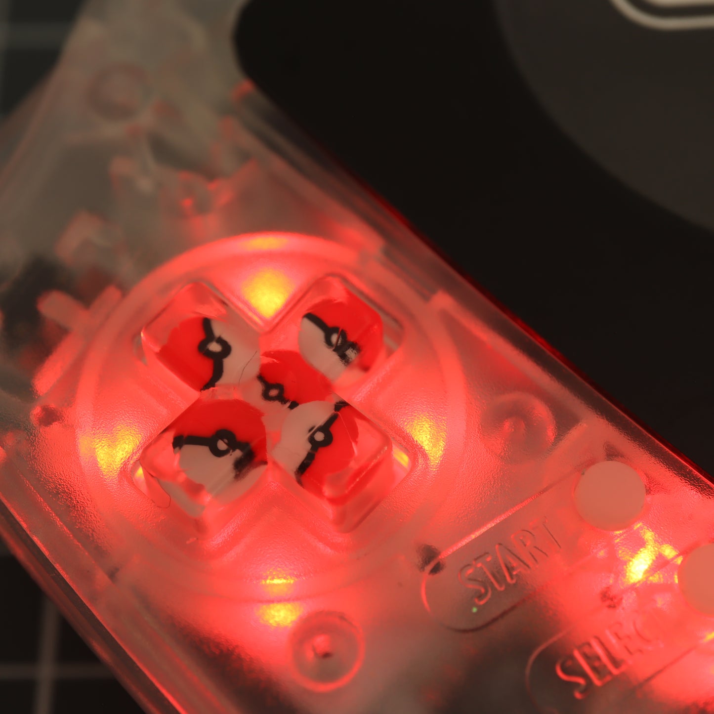 A close up of a labfifteen Game Boy Advance with custom-cast Pokeball buttons.