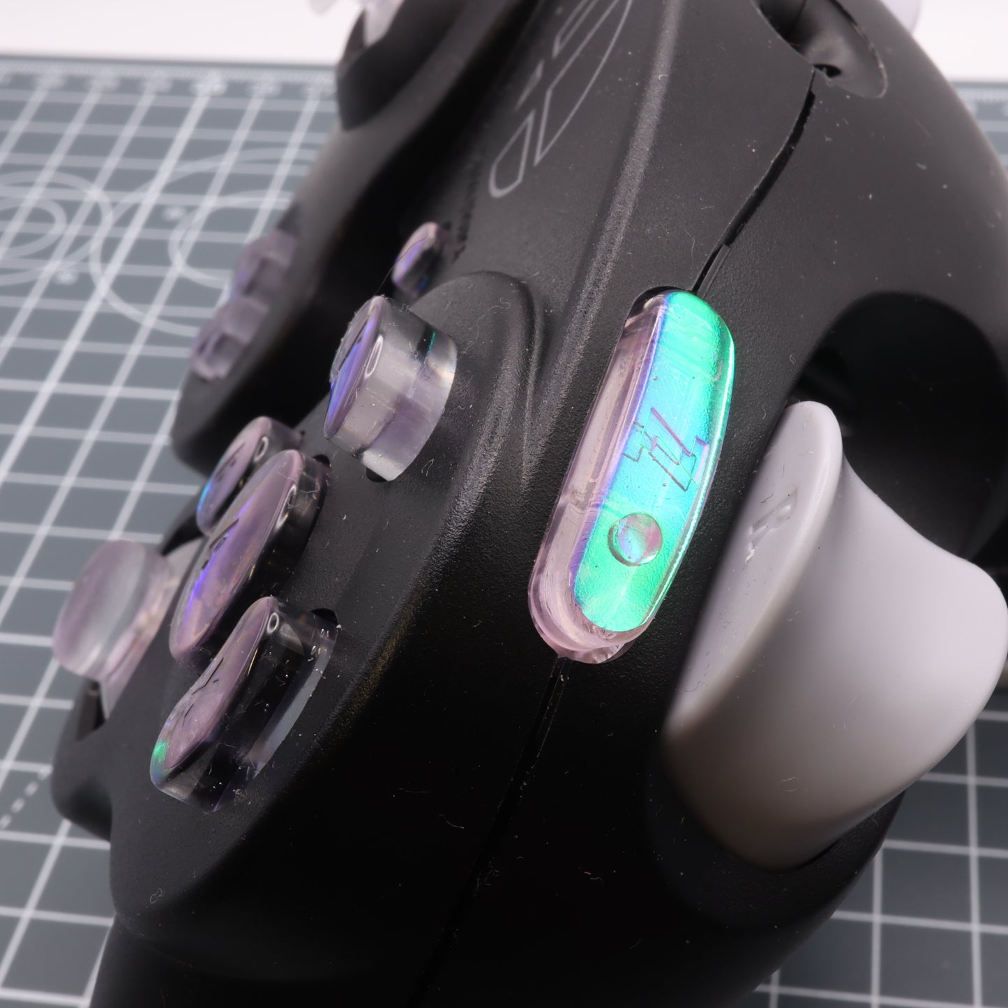 Close-up of a GameCube - Custom Button - Cool Opal controller showing its buttons, tracking sensors, and dichroic effect.