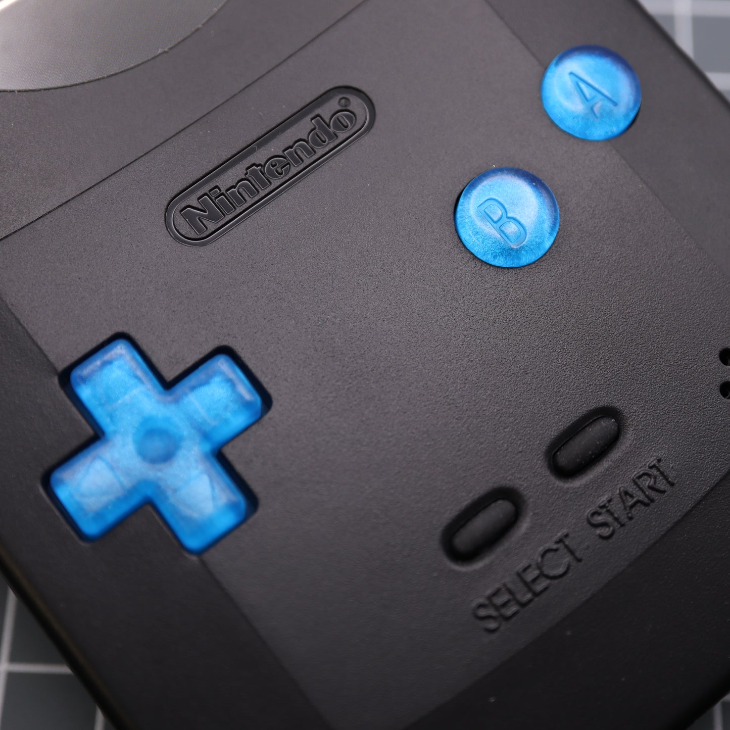 A set of Game Boy Color blueberry candy buttons made by lab fifteen co inside black games console