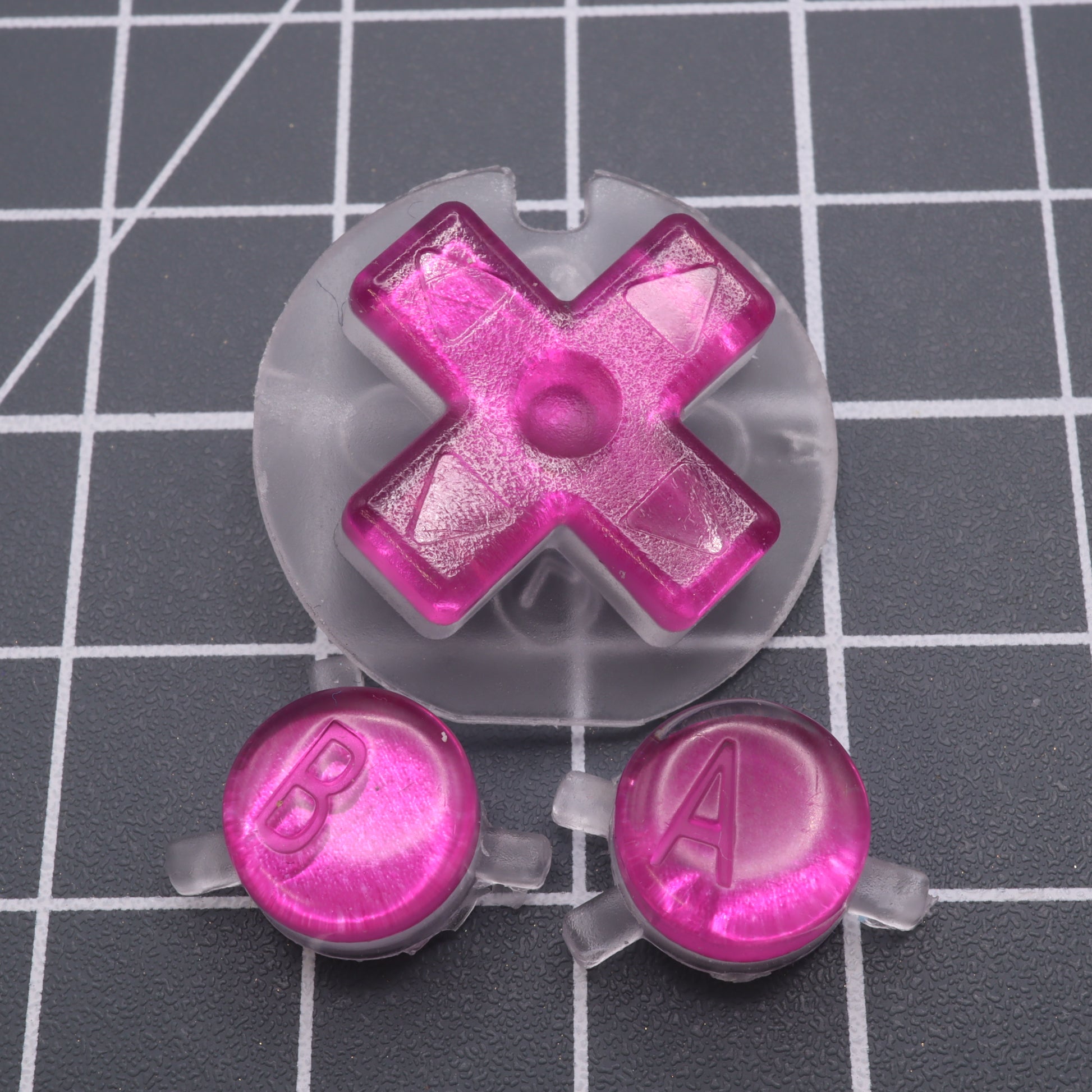 Game Boy Color custom resin buttons by lab fifteen co chrome pink colour on a table.