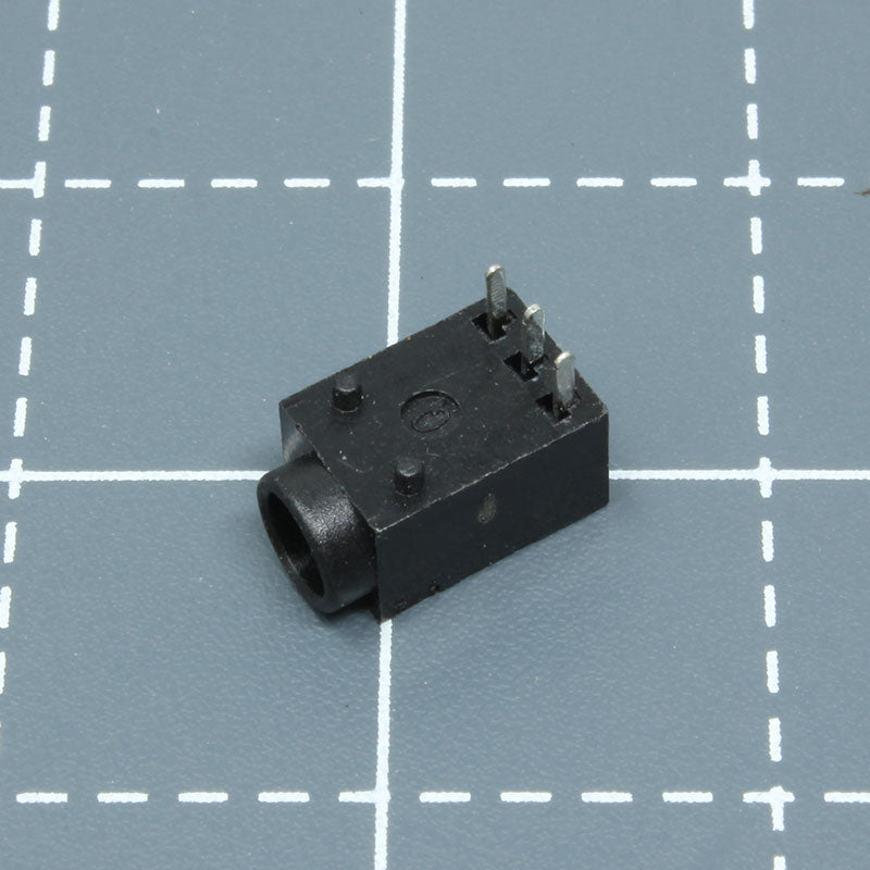 A small black labfifteen Atari Lynx DC jack electronic component on a table.