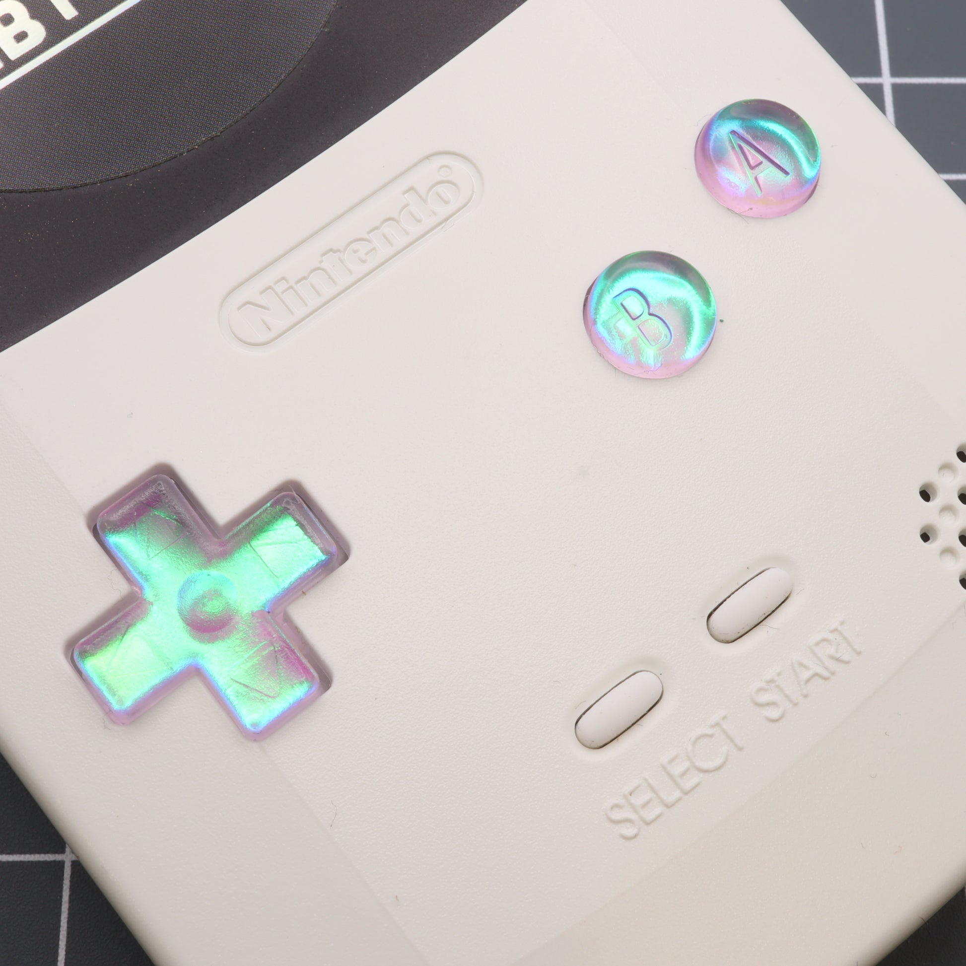 A white labfifteen Nintendo Game Boy Color with Cool Opal resin custom buttons.