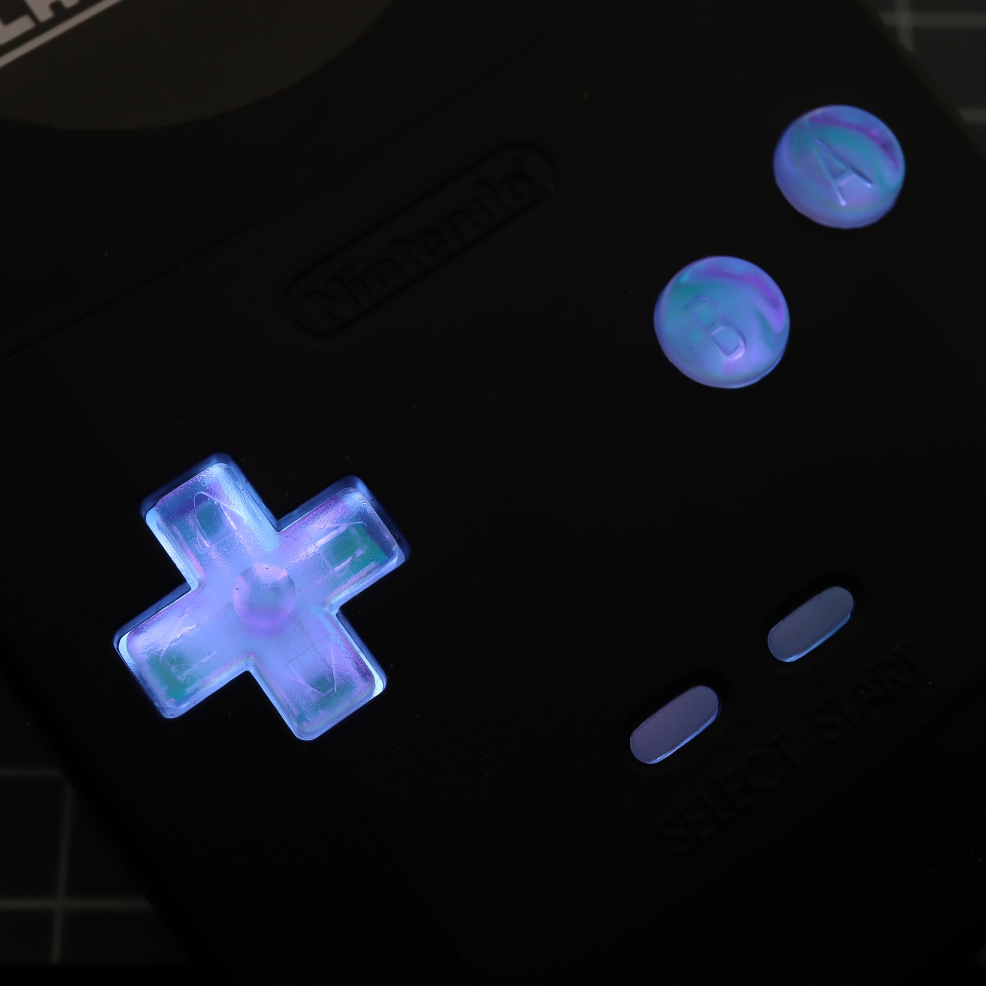 A black labfifteen Game Boy Color with glowing resin buttons.