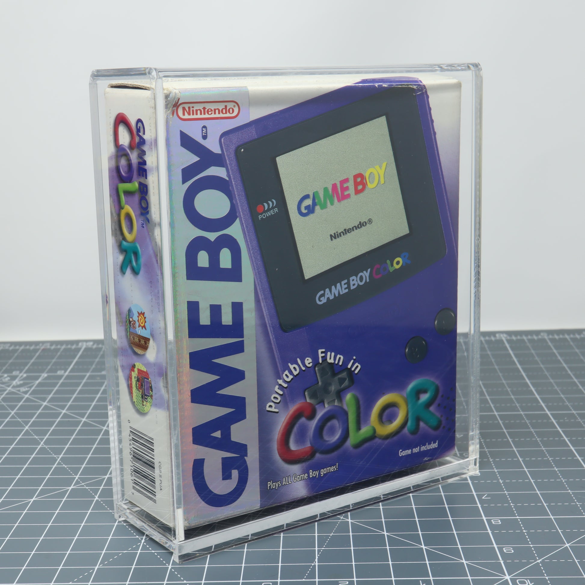 Game Boy Color Grape purple boxed console stored inside custom acrylic display capsule front image