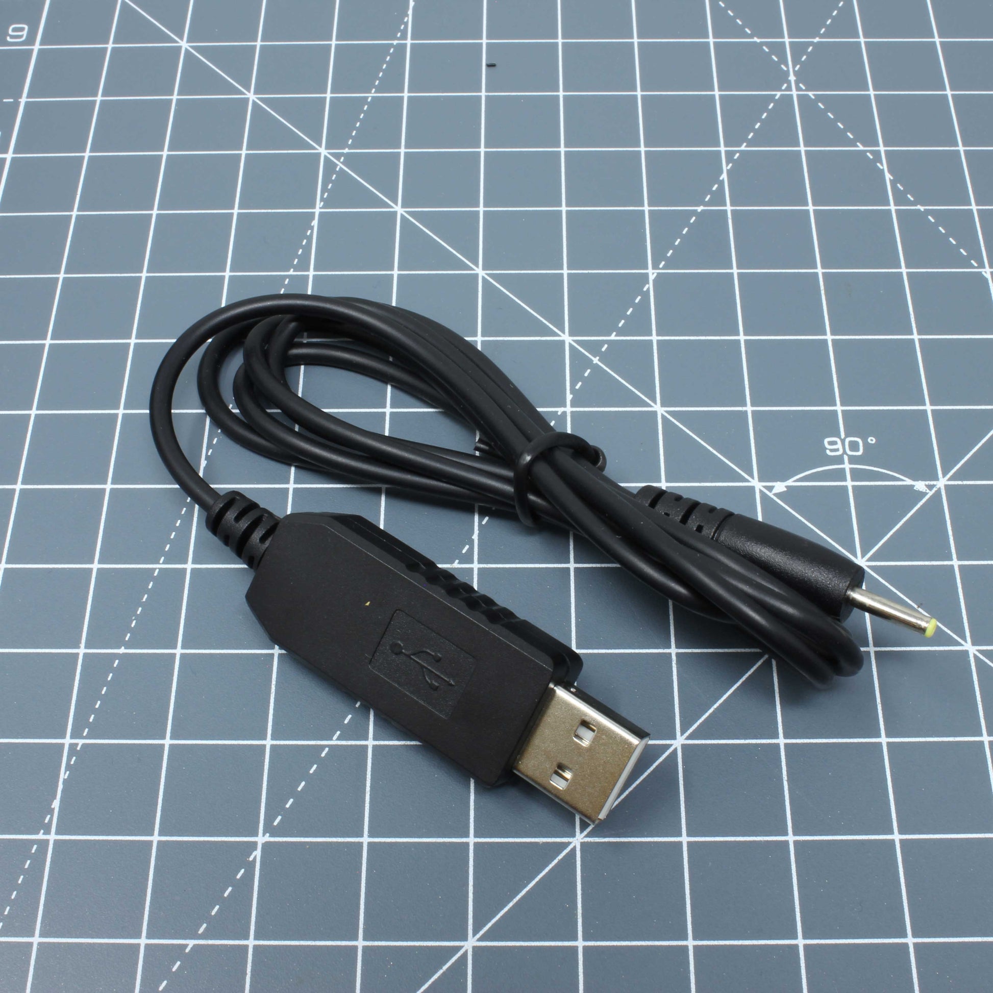 A Labfifteenco black USB power cable on a piece of paper for Game Boy Color/Pocket/Light - Parts - 3.3V USB Cable.
